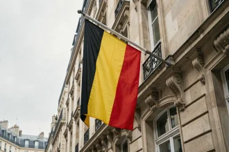 Drapeau belge noir jaune rouge accroché sur une façade haussmannienne à Paris, illustration du cadre légal en France