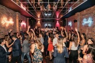Groupe de jeunes adultes dansant dans un nightclub animé à Toulon avec décoration en brique apparente et néons colorés